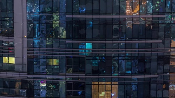 Fénylő ablaksorok emberekkel az apartmanházban éjszaka.. — Stock Fotó