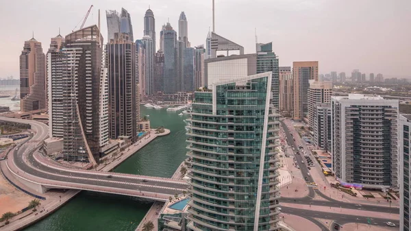 Vista aérea de los rascacielos residenciales y de oficinas de Dubai Marina con timelapse de día a noche frente al mar —  Fotos de Stock