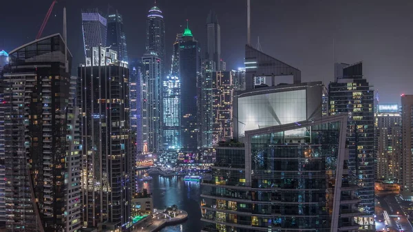 Pemandangan udara Dubai Marina perumahan dan pencakar langit kantor dengan tepi laut malam timelapse — Stok Foto