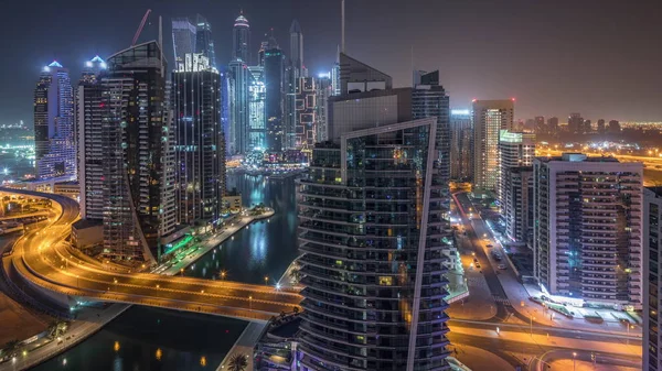 Vista aérea de los rascacielos residenciales y de oficinas de Dubai Marina con timelapse nocturno frente al mar — Foto de Stock