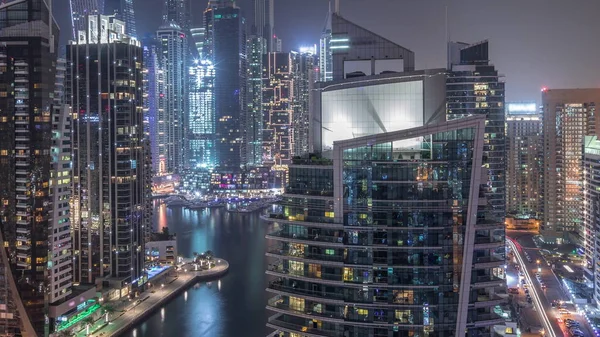 Vista aérea de los rascacielos residenciales y de oficinas de Dubai Marina con timelapse nocturno frente al mar —  Fotos de Stock