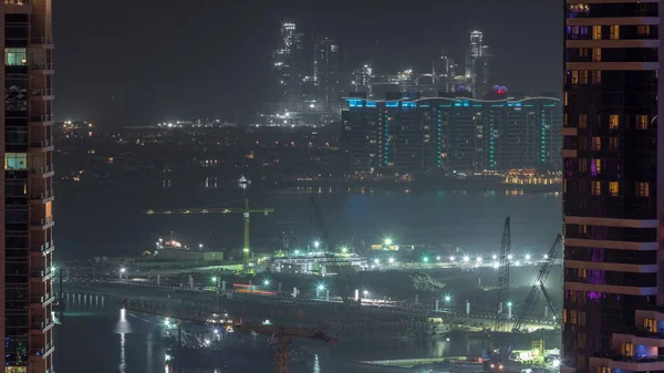 Widok z lotu ptaka na Dubai Marina drapacze chmur z placu budowy i Palm Jumeirah Island na tle nocy timelapse. — Zdjęcie stockowe
