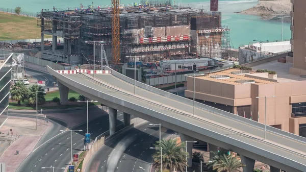 Vista aérea de los rascacielos del puerto deportivo de Dubái con obras de construcción y Palm Jumeirah Island en el timelapse de fondo . —  Fotos de Stock