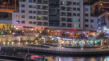 Dubai Marina Limanı 'ndaki rıhtım güvertesi gece uçuşları. Dubai, Birleşik Arap Emirlikleri