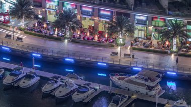 Dubai Marina Limanı 'ndaki rıhtım güvertesi gece uçuşları. Dubai, Birleşik Arap Emirlikleri