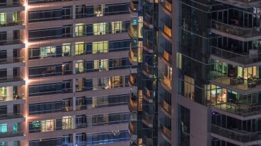 Geceleri apartmanda insanların oturduğu parlak pencereler..