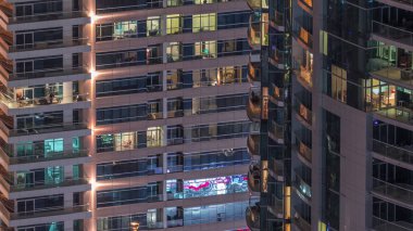 Geceleri apartmanda insanların oturduğu parlak pencereler..