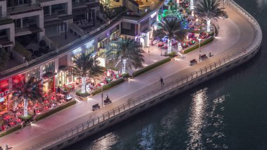 Dubai Marina Limanı 'ndaki rıhtım güvertesi gece uçuşları. Dubai, Birleşik Arap Emirlikleri