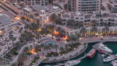 Dubai Marina Yürüyüşü Çeşme ve palmiyelerle Gece gündüz gökyüzü görüntüsüyle