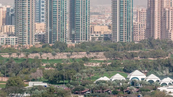 Dubaj Golfové hřiště s městskou krajinou Gereens a Tecom okresy na pozadí letecké timelapse — Stock fotografie