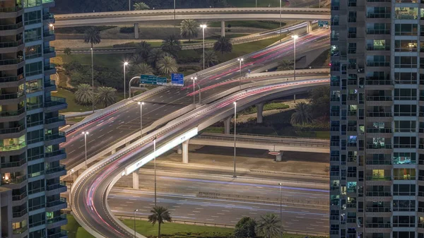 Dubai Marina salida de la carretera entre rascacielos, espagueti cruce aéreo noche timelapse — Foto de Stock