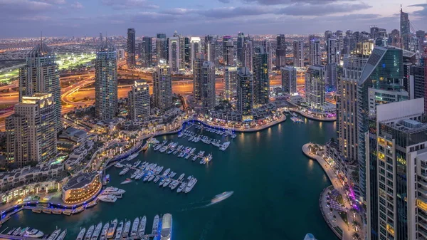 Dubai Marina arranha-céus e torres do lago jumeirah vista do topo do dia aéreo para a noite timelapse nos Emirados Árabes Unidos . — Fotografia de Stock