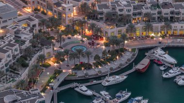 Dubai Marina Yürüyüşü Çeşme ve palmiyelerle Gece gündüz gökyüzü görüntüsüyle