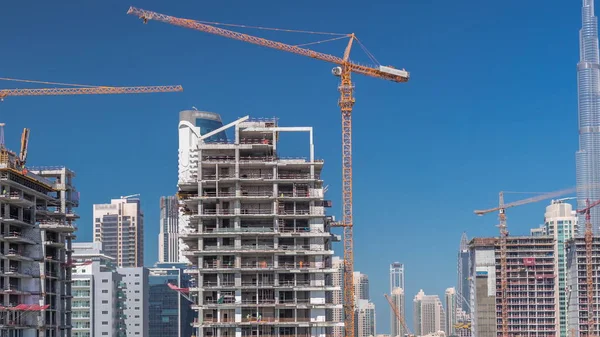 Luchtfoto van een wolkenkrabber in aanbouw met enorme kranen timelapse in Dubai. — Stockfoto