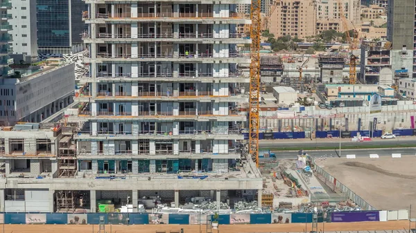 Vista aérea de um arranha-céus em construção com enormes guindastes timelapse em Dubai . — Fotografia de Stock