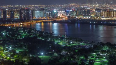 Park ve yola yakın gece şehri. Işıklar ve yüksek trafik zamanı var.