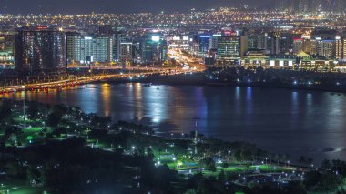 Park ve yola yakın gece şehri. Işıklar ve yüksek trafik zamanı var.