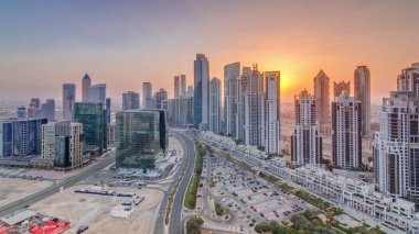 Günbatımında Dubai şehrinde yoğun trafiği olan büyük gökdelenleri ve yolları olan lüks bir şehir.