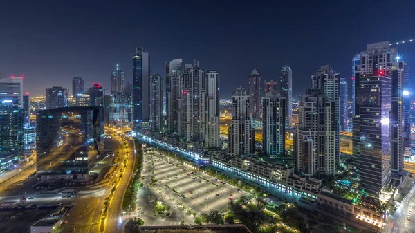 位于乌艾迪拜商务湾的现代化住宅和办公大楼，内有许多塔楼，夜间空中穿行. — 图库照片