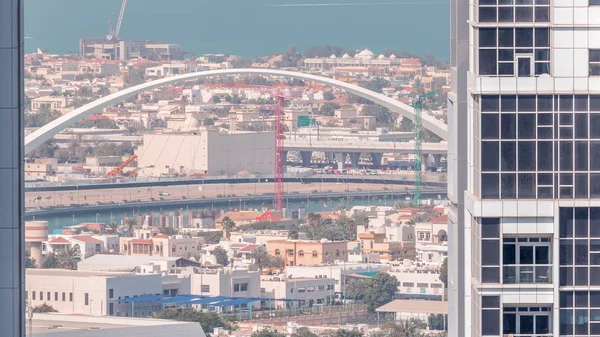 Puente peatonal sobre el canal de agua de Dubái timelapse aéreo entre torres en la bahía de negocios desde arriba — Foto de Stock