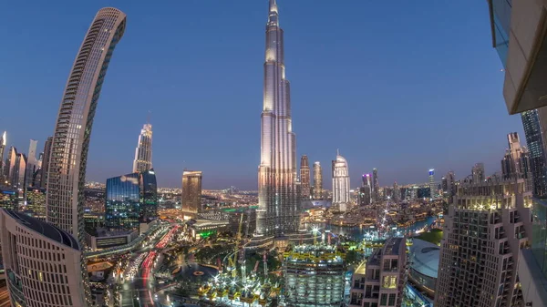 Panoramisch uitzicht op de skyline van Dubai centrum na zonsondergang met een winkelcentrum, fonteinen en wolkenkrabbers lucht dag tot nacht timelapse — Stockfoto