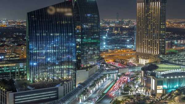 Dubai downtown street with busy traffic and skyscrapers around night timelapse.