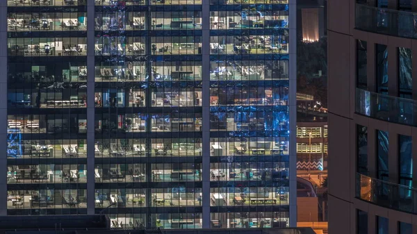 Kancelářského exteriéru během pozdní noci s vnitřními světly a lidé pracující v nočních hodinách — Stock fotografie