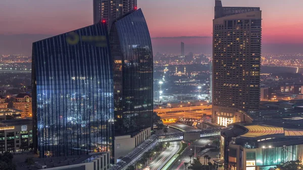 Dubai belvárosi utcája forgalmas forgalommal és felhőkarcolókkal éjjel-nappal. — Stock Fotó