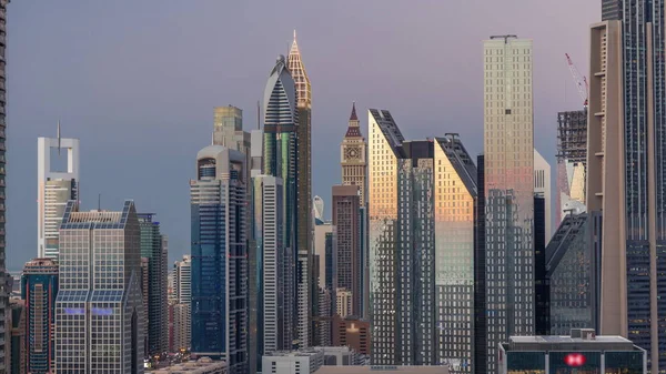 Vista aérea de novos arranha-céus e edifícios altos no Dubai dia a noite timelapse — Fotografia de Stock