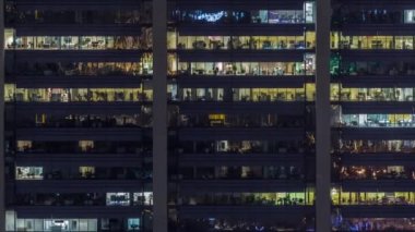 İş faaliyetini gösteren modern bir gökdelenin cephesindeki ofis pencereleri