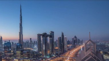Dubai şehir merkezi silueti en yüksek gökdelenler ve karayolu kavşak gece gündüz timelapse üzerinde en yoğun trafik ile