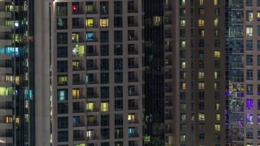 Çok katlı binanın içinde aydınlatma ve apartmanlarda zaman atlamalı insanları hareket ettiren pencereler.