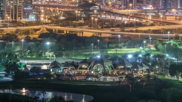 Campo da golf e Dubai Marina grattacieli illuminati notte timelapse, Dubai, Emirati Arabi Uniti — Video Stock