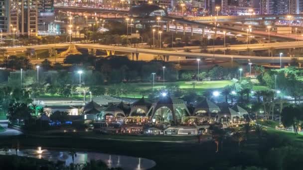 Campo de golfe e Dubai Marina iluminados arranha-céus noite timelapse, Dubai, Emirados Árabes Unidos — Vídeo de Stock