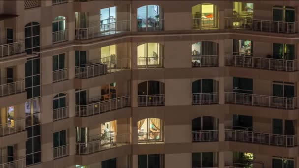 Fenêtres de l'immeuble de plusieurs étages avec éclairage intérieur et les personnes en mouvement dans les appartements timelapse . — Video