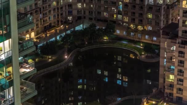 Dubai, Bae'de Yeşiller semtinde ki insan yapımı göl ve konut binaları gece saatlerinde — Stok video