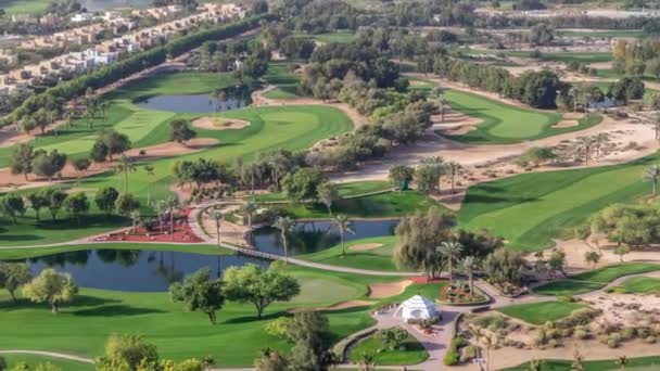 Вид з повітря на вілли та будинки з поле для гольфу з зеленим газоном та озерами — стокове відео