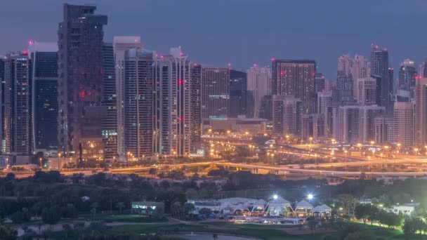 Jumeirah lake towers and Dubai marina skyscrapers and golf course night to day timelapse, Dubai, United Arab Emirates — Stock Video