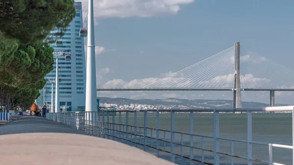 View from river Tagus waterfront of Lisbon 's Nations park and Vasco da Gama Bridge timelapse, Portugal — стоковое фото