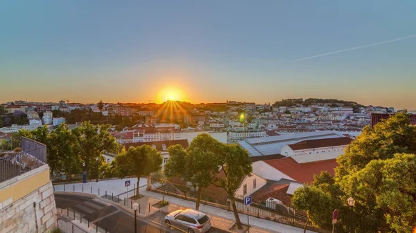 Zonsopgang boven de skyline van Lissabon vanuit het oogpunt van St. Peter van Alcantara, Portugal. — Stockfoto