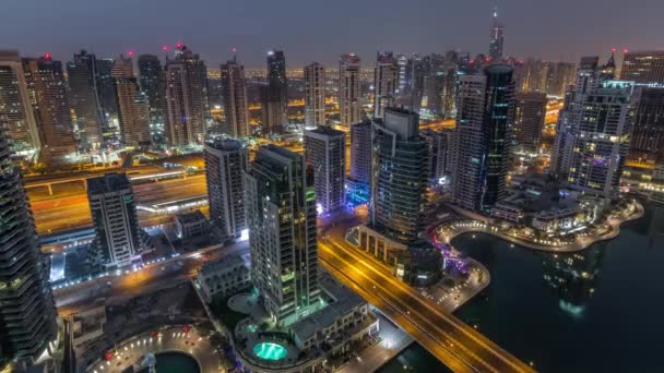 Widok z lotu ptaka Dubai Marina nocy do dnia timelapse. Nowoczesne wieże i ruch na drodze — Wideo stockowe