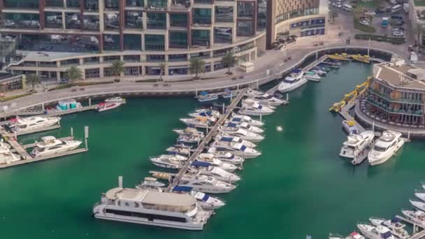 Vista aérea de yates flotando en Dubai marina timelapse. Los barcos blancos están en el agua del canal verde . — Vídeos de Stock