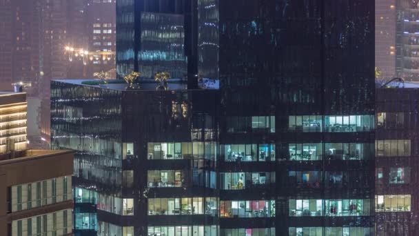 Luces en ventanas del moderno edificio de oficinas de varios pisos en un entorno urbano durante la noche timelapse — Vídeo de stock
