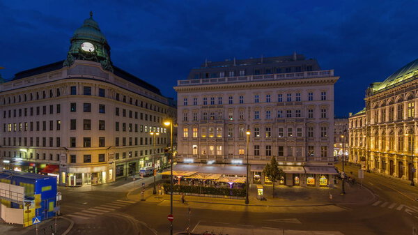 Albertina Square aerial day to night transition timelapse with illuminated historic buildings, tourist buses, people and traffic in downtown Vienna, Austria
