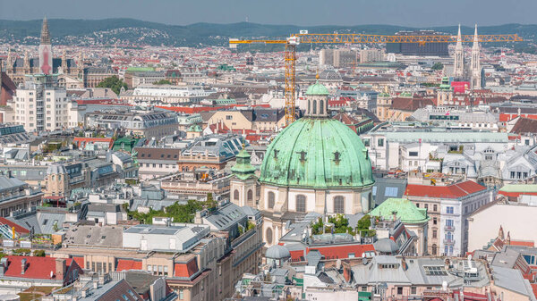 Panoramic aerial view of Vienna, austria, from south tower of st. stephen's cathedral timelapse. City skyline with historic buildings roofs from above at sunny day