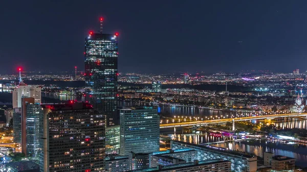 Vista panorâmica aérea sobre a cidade de Viena com arranha-céus, edifícios históricos e um passeio à beira-rio noite timelapse na Áustria . — Fotografia de Stock