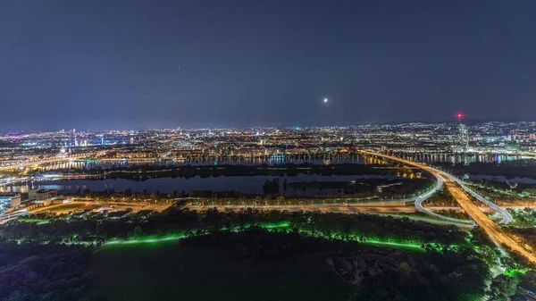 Aerial panoramic view over Vienna city with skyscrapers, historic buildings and a riverside promenade night timelapse in Austria. — 스톡 사진