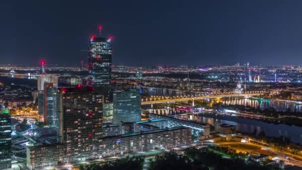 Légi panorámás kilátás Bécs városára felhőkarcolókkal, történelmi épületekkel és egy folyóparti sétány éjszakai időtöltéssel Ausztriában. — Stock videók
