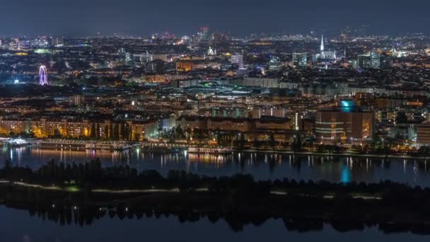 高層ビル、歴史的建造物、オーストリアの川沿いの遊歩道の夜のタイムラプスを持つウィーン市内の空中パノラマビュー. — ストック動画
