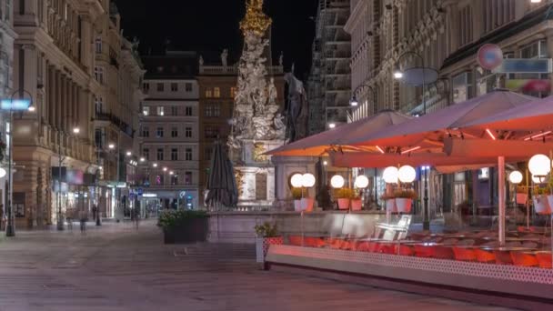 人々はウィーンの旧市街のメインストリートであるGraben St.夜のタイムラプスを歩いています。. — ストック動画